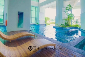 Zona de piscina con sillones de descanso y un cartel que indica una profundidad de 1,2 metros.