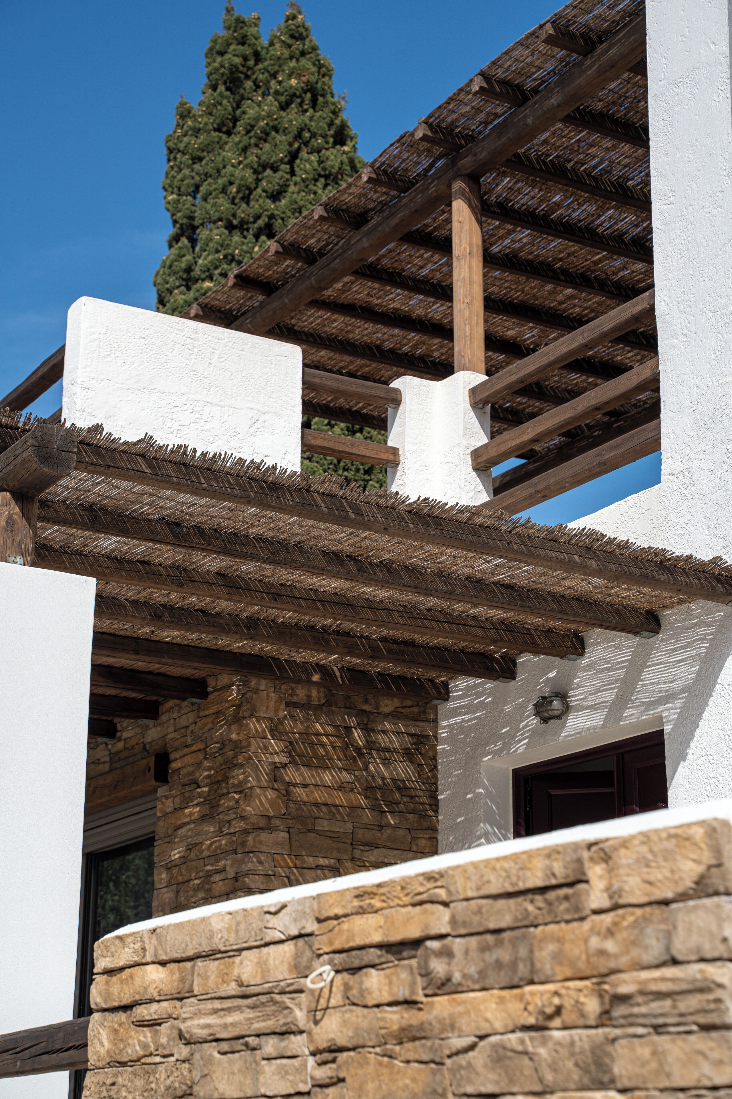 A building with a stone facade, wooden beams, and a thatched roof.
