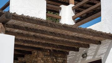 A building with a stone facade, wooden beams, and a thatched roof.