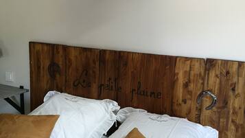 Een bed met een houten hoofdbord, witte en bruine kussens, en drie zwarte wandlampen.