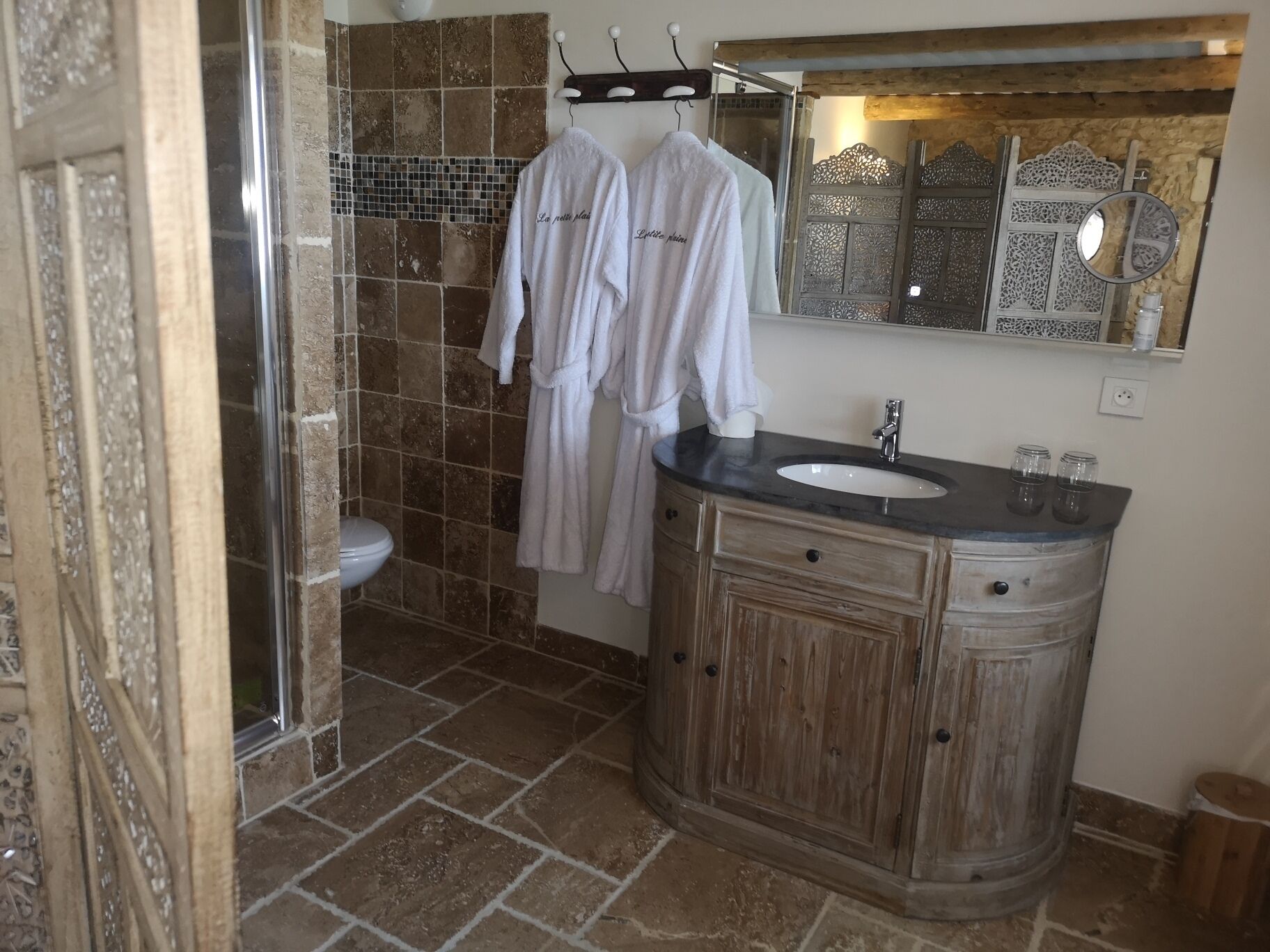 Ein Badezimmer mit Dusche, Waschbecken und Spiegel.
