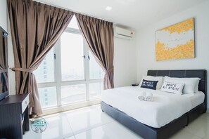 Habitación de hotel moderna con una cama grande, dos almohadas, un escritorio y una ventana con cortinas.