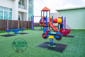 Un parque infantil con tobogán, estructuras para escalar y columpios.