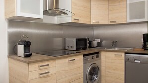 A modern kitchen with wooden cabinets, a built-in microwave, a coffee maker, and a dishwasher.