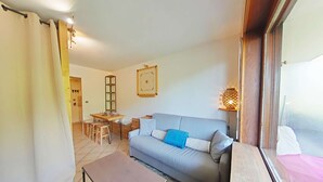 Ein gemütliches Wohnzimmer mit einer Couch, einem Couchtisch und einem Essbereich mit Stühlen und einem Tisch.
