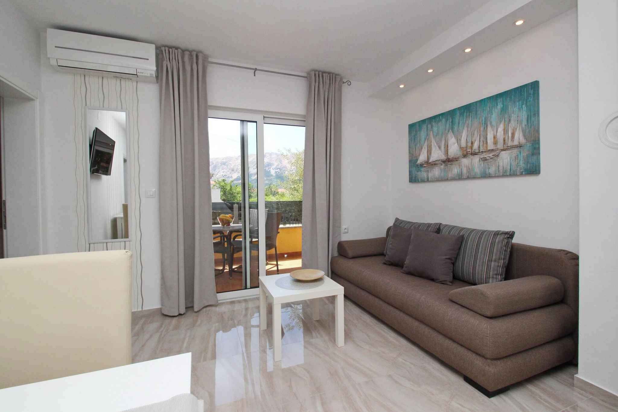 A modern living room with a brown sofa, a small white table, and a painting of sailboats on the wall.