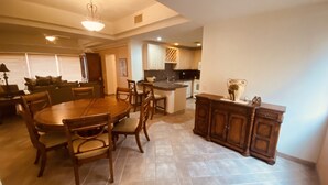 Un espacio habitable amplio con una mesa de comedor y sillas, una cocina con isla central, y una zona de estar acogedora con sofá y sillas.