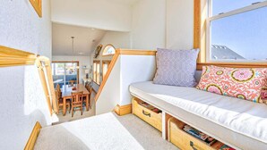 A cozy room with a built-in bed, a wooden staircase, and a dining area.