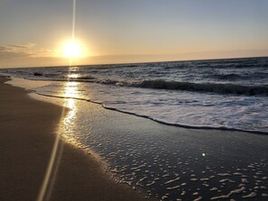 A beach with the sun setting over the ocean, waves gently lapping the shore. - Sunny 2 room Relaxing oasis with terrace - Ferienanlage am Bakenberg Rugana (A32) (Kreptitz)