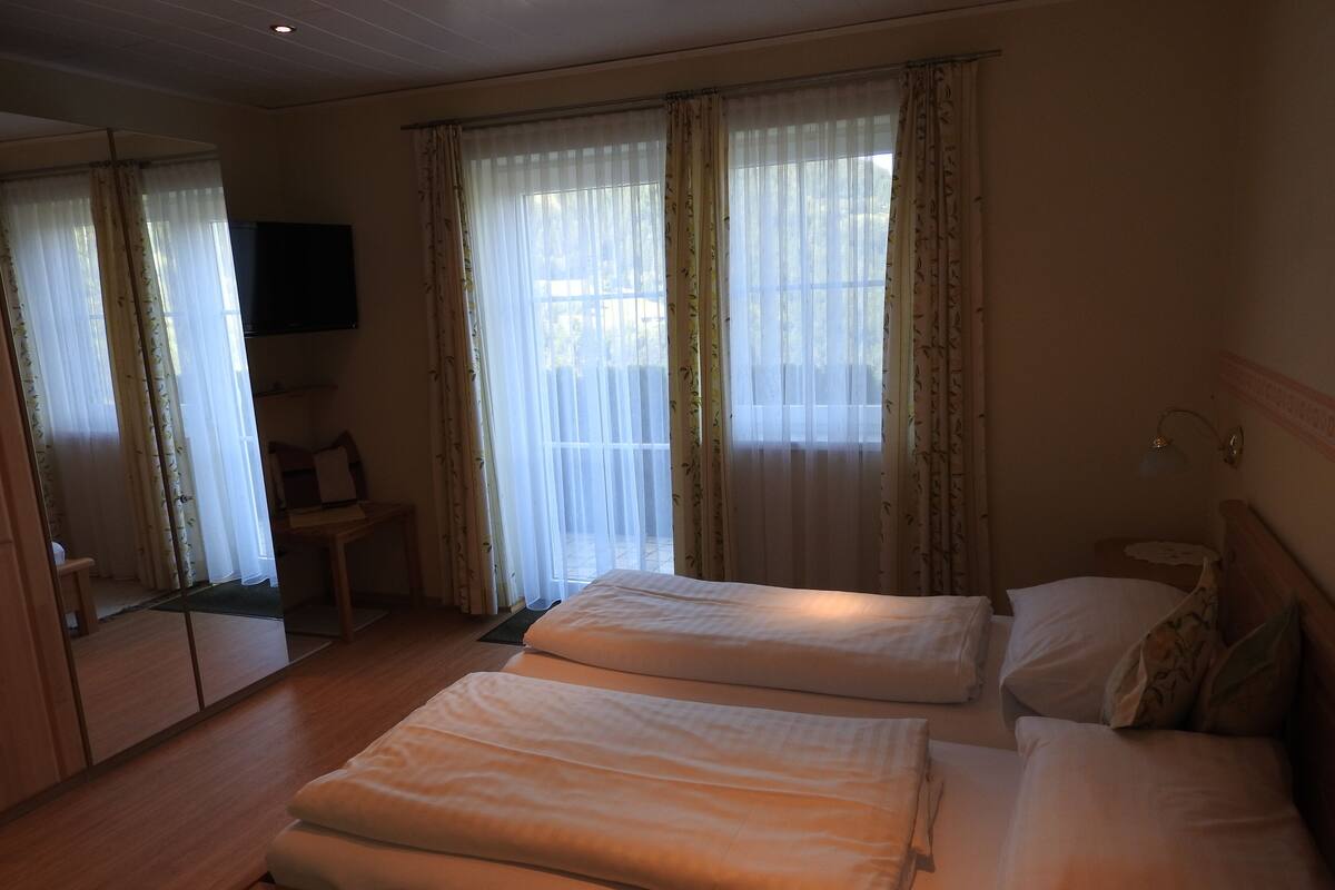 Une chambre d’hôtel avec deux lits, une télévision et un bureau.
