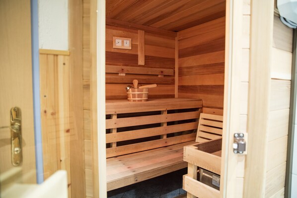 A sauna with wooden benches and a wooden bench with a bucket and ladle. - Ertlschweigerhaus (Irdning-Donnersbachtal)