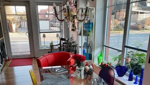 A modern living room with a glass coffee table, red sofa, and a large window with blinds. - Vacation luck hit (Meppen)