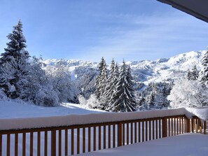 A snow-covered landscape with a wooden deck and snow-laden trees. - Cozy apartment near slopes - 6 guests (Méribel)