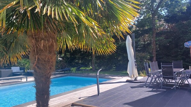 A swimming pool with lounge chairs and a basketball court.