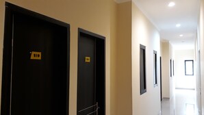 Ein Hotelgang mit schwarzen Türen, jede Tür ist mit einer Nummer gekennzeichnet.