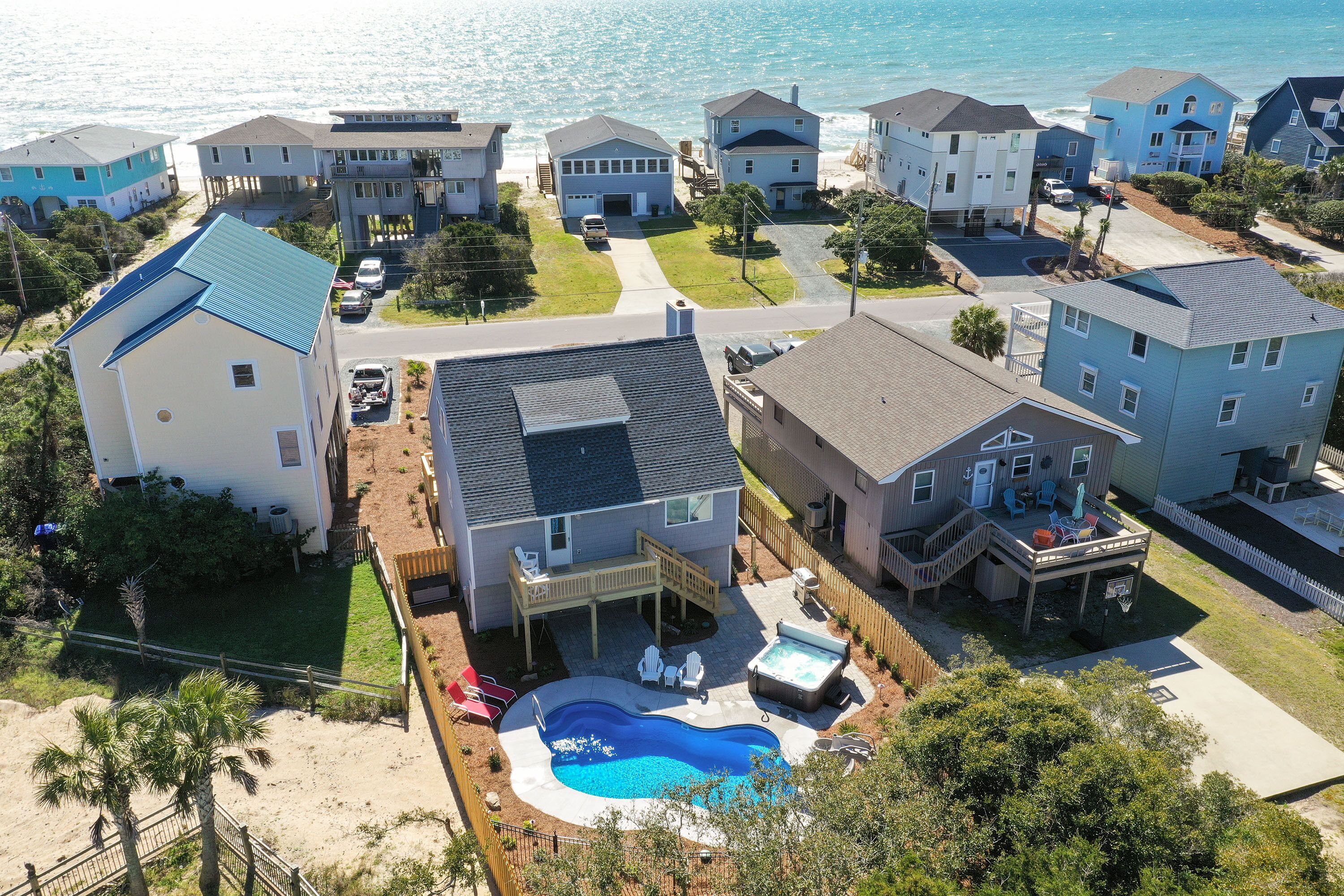 A residential area with houses, a swimming pool, and a beach.