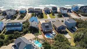 A coastal residential area with houses, a swimming pool, and a beach. - Your Ultimate  Retreat – Steps from Beach with PVT Heated Pool, Slide & Hot Tub! (Surf City)