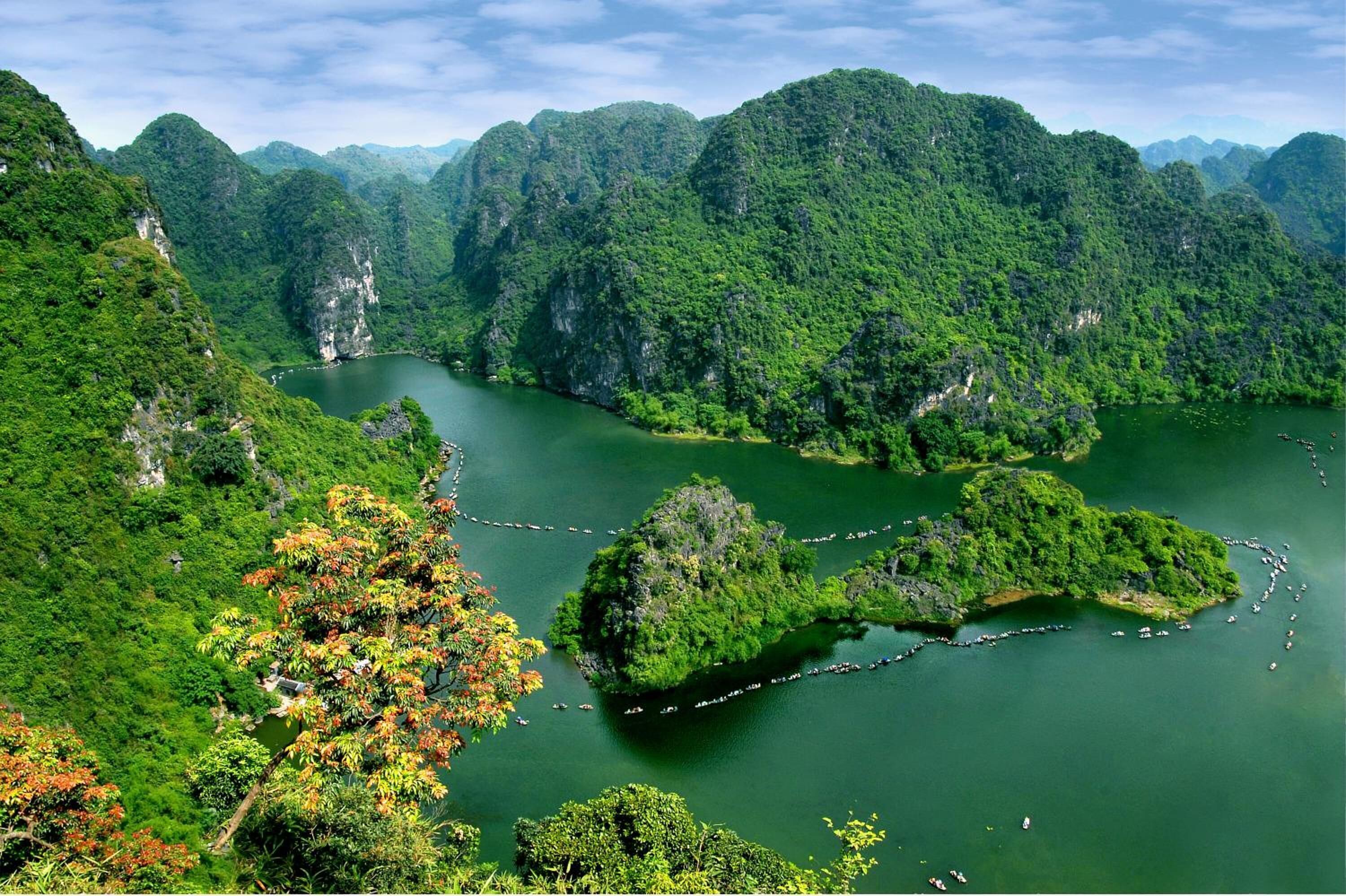 Un paisaje exuberante y verde con un río serpenteando a través de una zona montañosa.