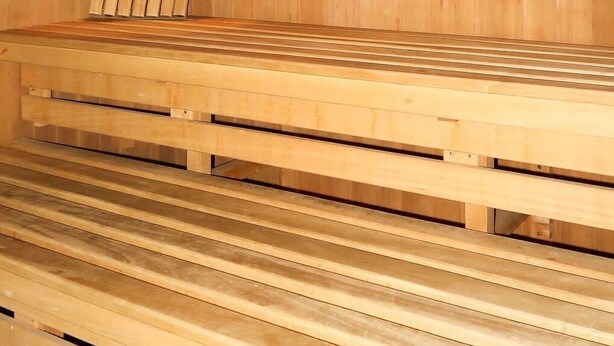 Un sauna avec des bancs en bois et un système de chauffage central.