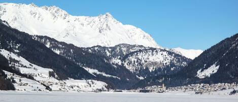Paisatge de muntanya cobert de neu amb un poble a la vall.
