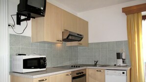 Cocina compacta equipada con microondas, estufa, horno y lavavajillas.