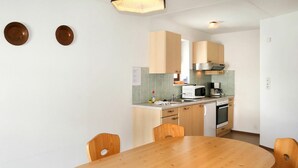 Una cocina moderna con armarios de madera, una campana extractora de acero inoxidable y un horno empotrado.