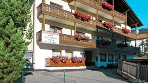 Un edificio de varios pisos con balcones decorados con macetas de flores.