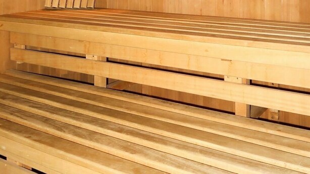 Een sauna met houten banken en een centrale verwarming.