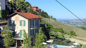 Une villa avec piscine, entourée d’une végétation luxuriante et de vignobles.