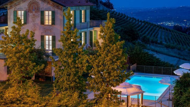 Une grande maison avec une piscine et une vue sur la campagne.