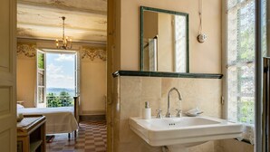 Une salle de bain avec un grand lavabo, un miroir et une vue sur l’extérieur.