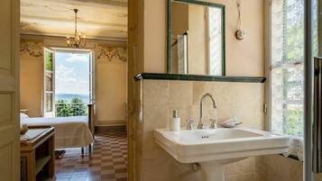 Un bagno con un lavandino grande, uno specchio e vista sull'esterno.