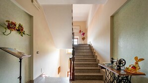 A staircase leading to a second floor, with a sewing machine and a small table with a rabbit figurine on the landing. - Nice apartment for 4 people with WIFI, A/C, pool, TV and patio (Castagnole Delle Lanze)