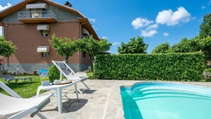 A two-story building with a swimming pool, outdoor seating, and a well-maintained garden. - Nice apartment for 4 people with WIFI, A/C, pool, TV and patio (Castagnole Delle Lanze)
