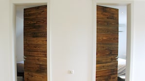 A room with a wooden door and a white wall.