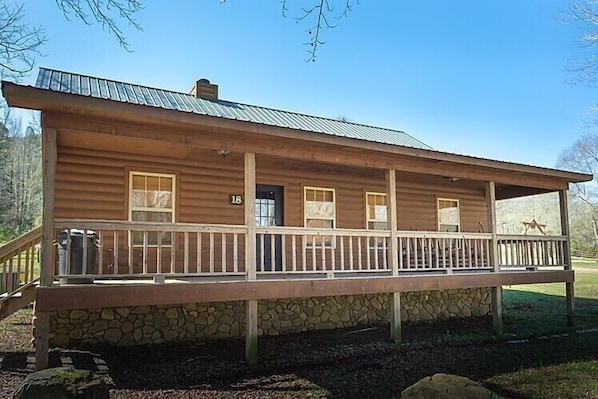 A rustic cabin with a stone foundation, a wooden porch, and a metal roof. - Pet Friendly Lobo Landing Cabin! (Heber Springs)