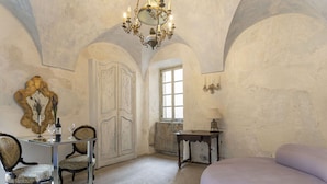 A room with a large arched ceiling, a chandelier, a desk with chairs, a bed, and a window. - Nice apartment for 7 people with WIFI and terrace (Pietrabruna)