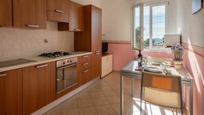 Una cucina moderna con mobili in legno, un piano cottura a gas e un'area pranzo con tavolo e sedie.