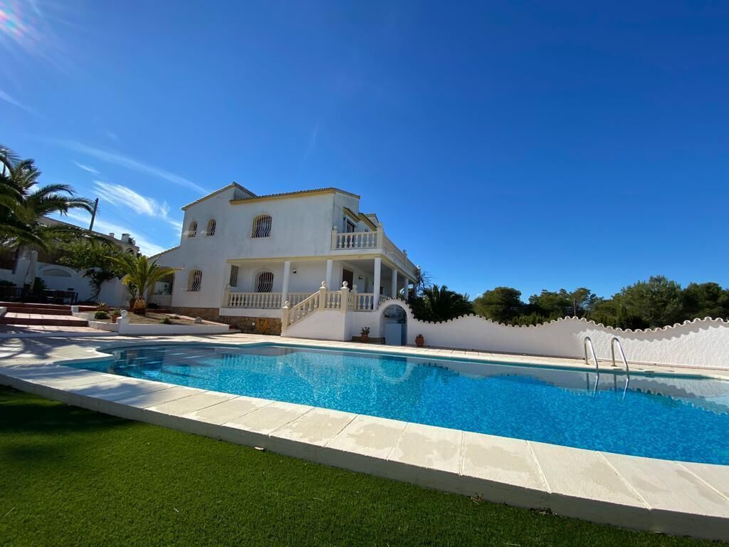 Une maison à deux étages avec une piscine à l’avant.