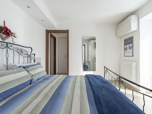 Un dormitorio con cama, radiador y ventana.
