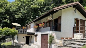 A two-story house with a stone facade, a balcony with flower pots, and a stone staircase leading to the entrance. - Wonderful private villa for 4 guests with WIFI, TV, terrace and pets allowed (Trarego)
