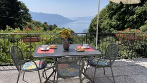 A table set outdoors with a view of mountains, surrounded by greenery and flowers. - Wonderful private villa for 4 guests with WIFI, TV, terrace and pets allowed (Trarego)