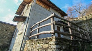 Ein rustikales Steinhaus mit Holzbalkon und geneigtem Dach.