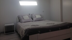 Ein Schlafzimmer mit Bett, Nachttisch und Wandleuchte.