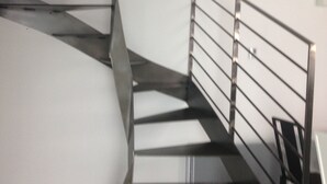 Eine moderne Treppe mit Metallgeländer, die zu einer oberen Etage führt.