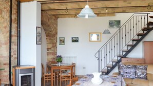 A cozy living room with a dining area, a fireplace, and a staircase. - Beautiful private villa for 4 people with WIFI, TV, terrace and pets allowed (Picciano)