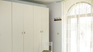 A room with a large wardrobe, a chair, and a patterned bedspread. - Beautiful private villa for 4 people with WIFI, TV, terrace and pets allowed (Picciano)