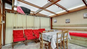 Een eethoek met rode, beklede banken en een tafel met een witte tafelkleed.
