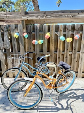 Bicycles parked in front of a charming fence, surrounded by trees.