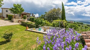 A stone house with a garden, outdoor seating, and purple flowers. - Beautiful apartment in villa with WIFI, pool, A/C, TV, terrace, pets allowed and panoramic view (Cennina)
